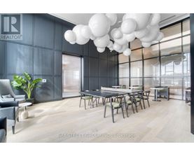 A modern dining room with a table set for six and a large window.
