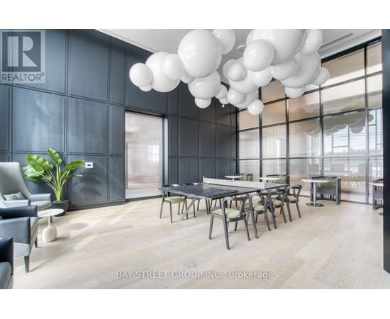 A modern dining room with a table set for six and a large window.