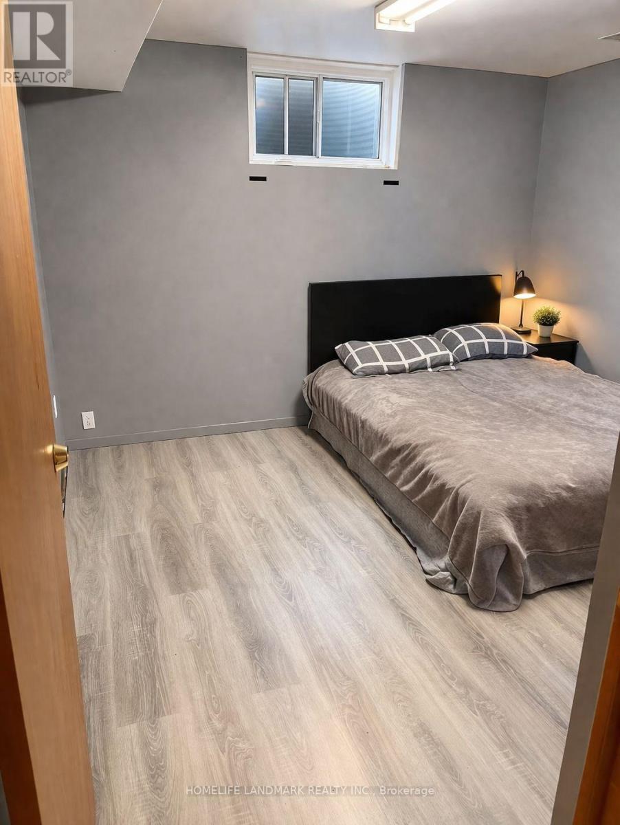 A bedroom with a bed, pillows, and a lamp.