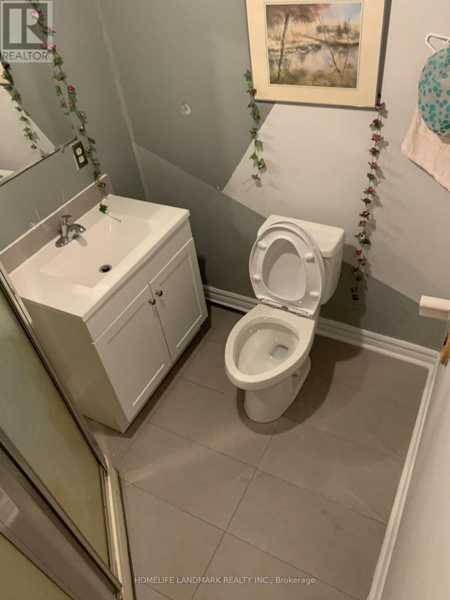 A white toilet in a bathroom with a white cabinet and a mirror.