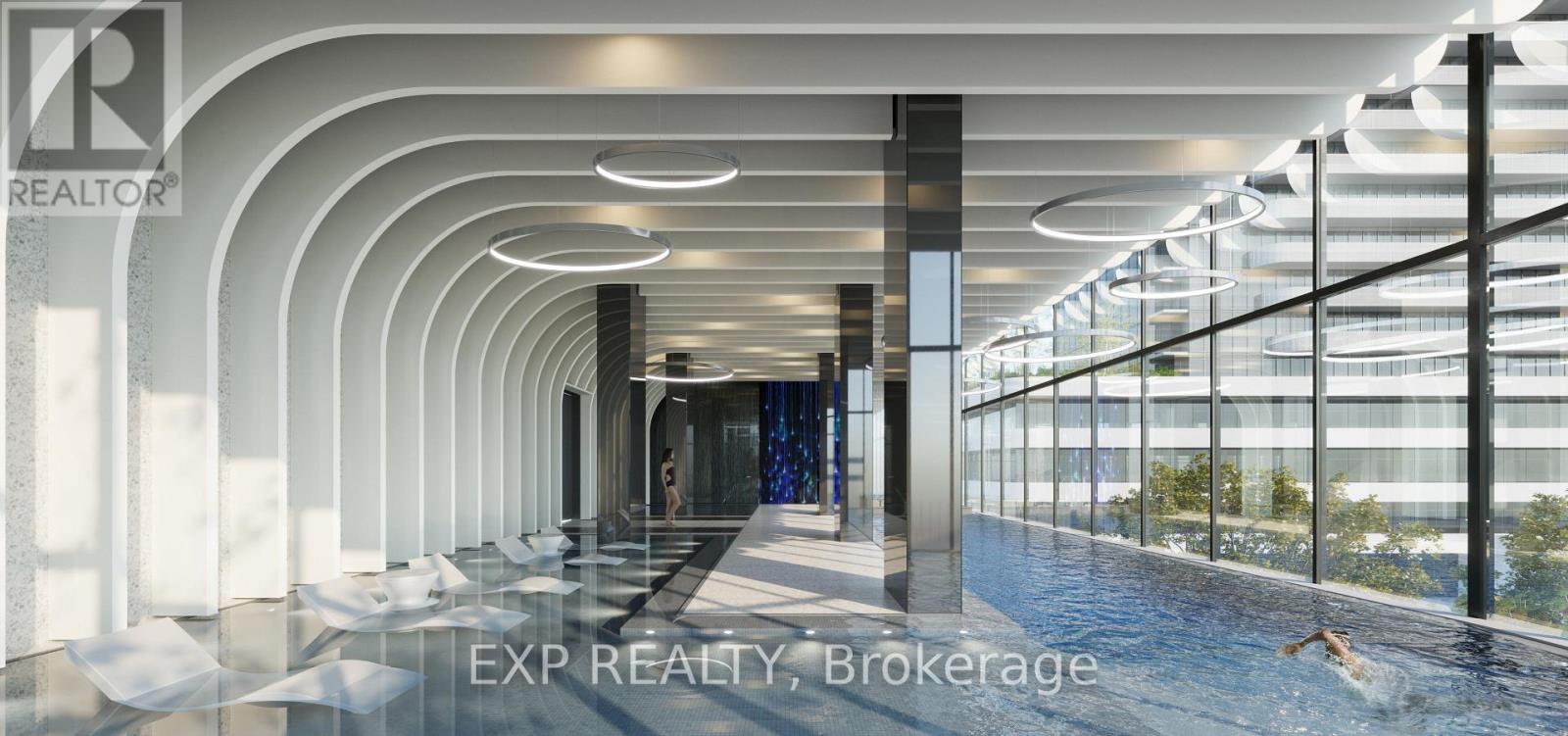 A modern indoor swimming pool area with a glass wall on one side.