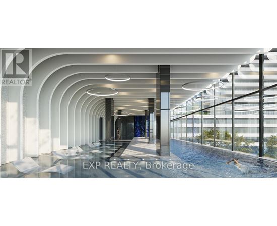 A modern indoor swimming pool area with a glass wall on one side.