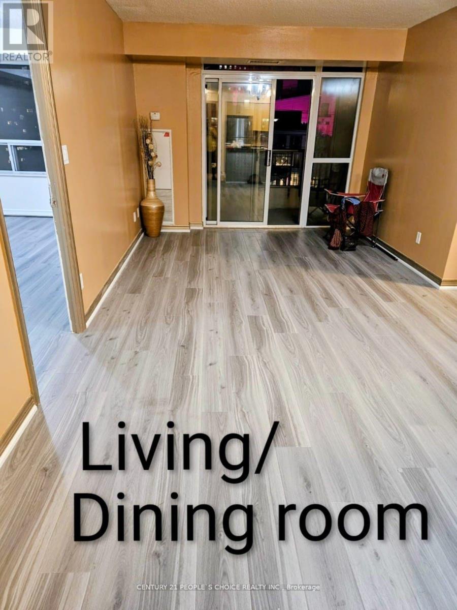 A living and dining room with wooden flooring and a sliding glass door.