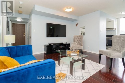 A blue couch sits in a living room with a glass coffee table in front of it.
