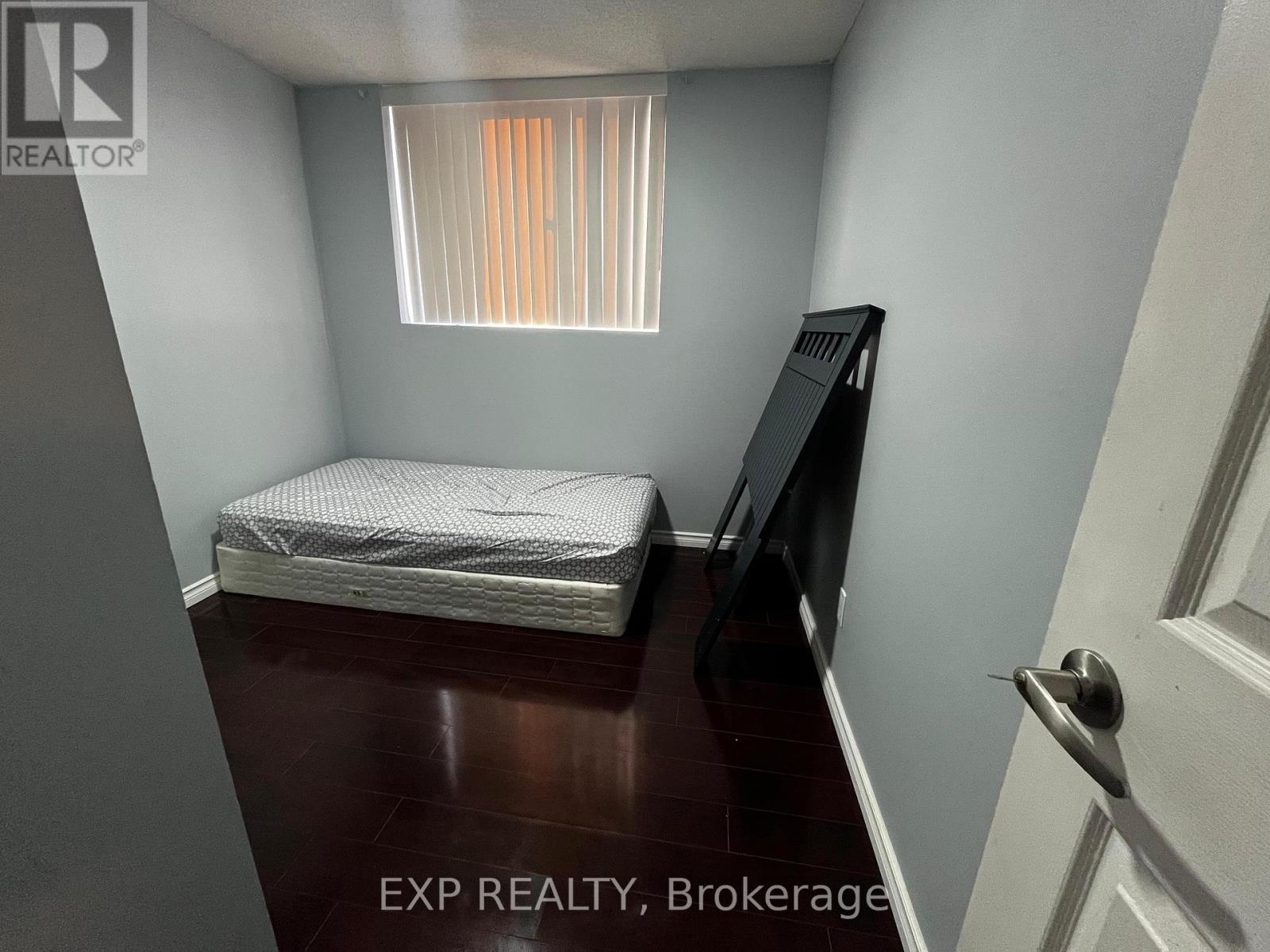 A small bedroom with a bed, dresser, and window.