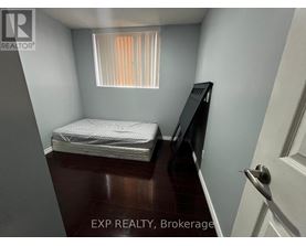 A small bedroom with a bed, dresser, and window.
