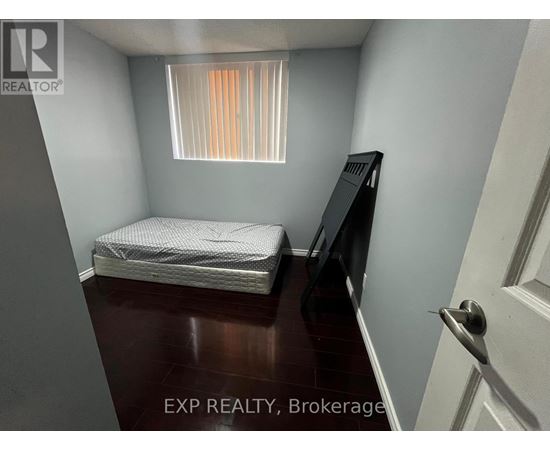A small bedroom with a bed, dresser, and window.