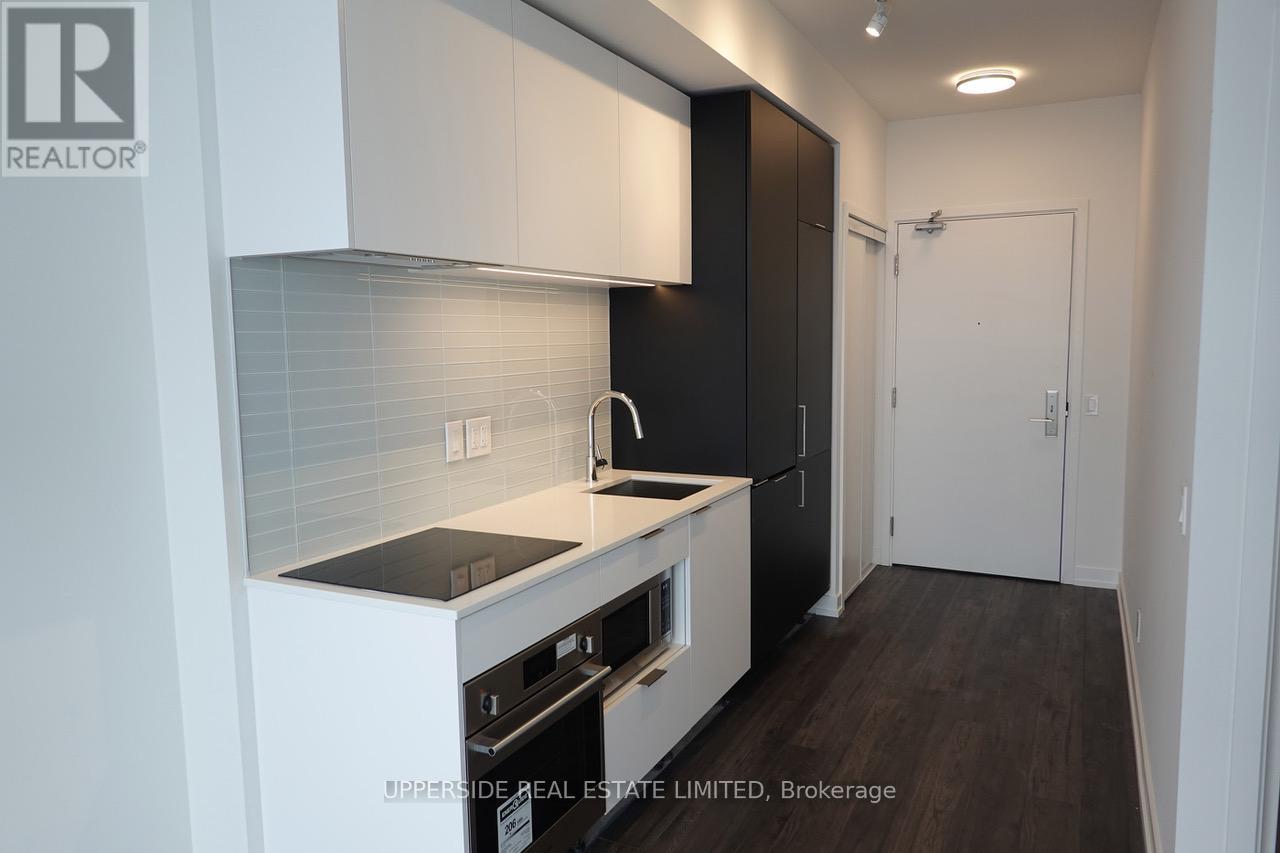 A kitchen with white cabinets and black appliances.