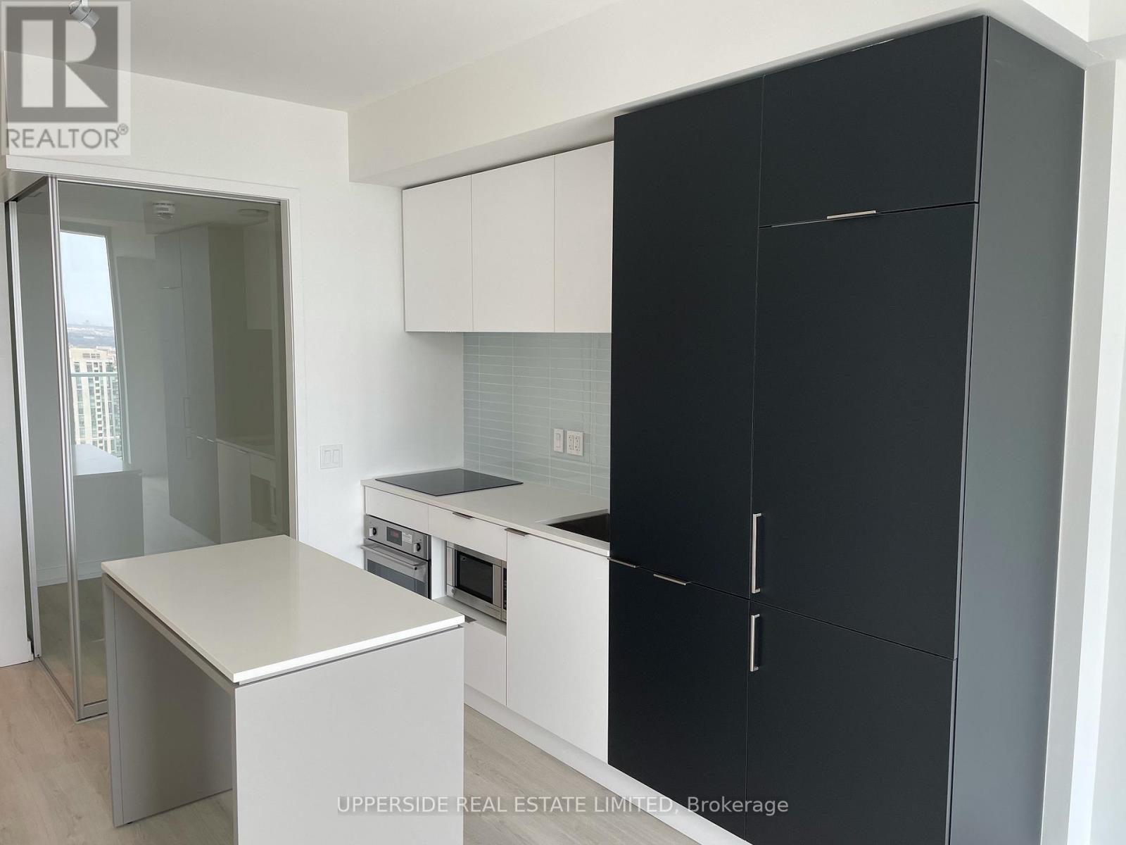 A kitchen with a black cabinet and a white counter.