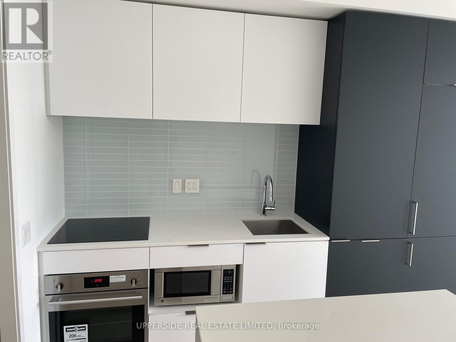 A kitchen with white cabinets and a black countertop.