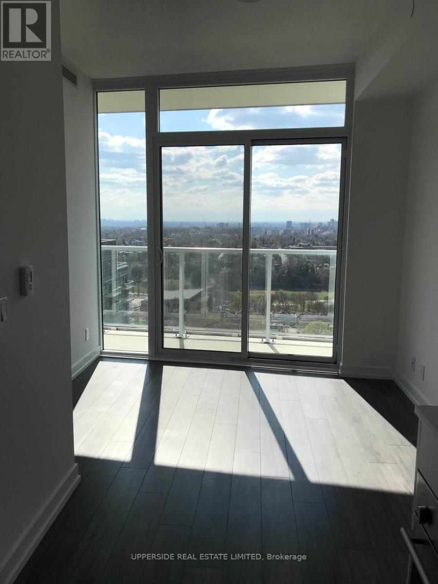 A room with a view of the city through a large window.