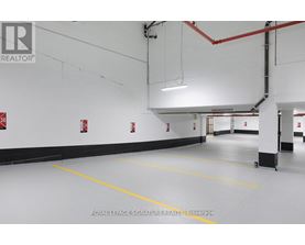 A spacious garage with yellow lines on the floor and red pipes on the ceiling.