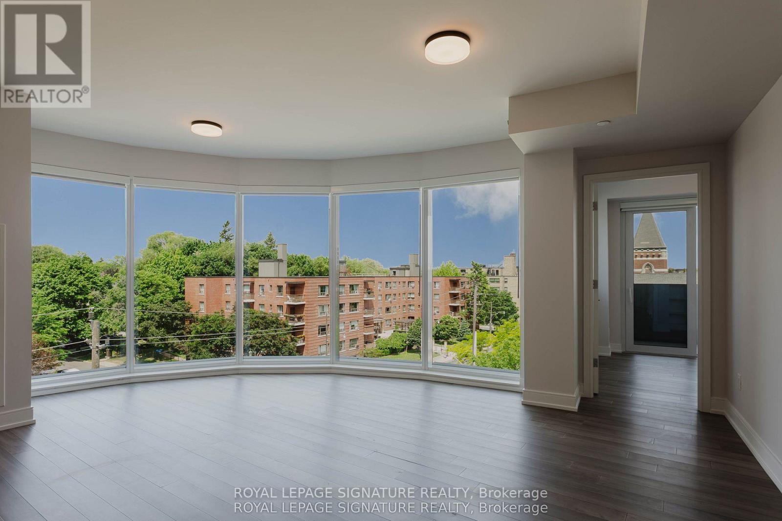 A large, empty room with a view of a cityscape through the windows.
