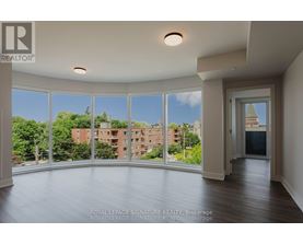 A large, empty room with a view of a cityscape through the windows.
