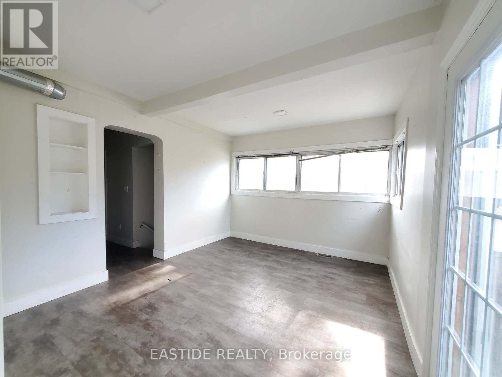 A room with a door and a window is for sale.