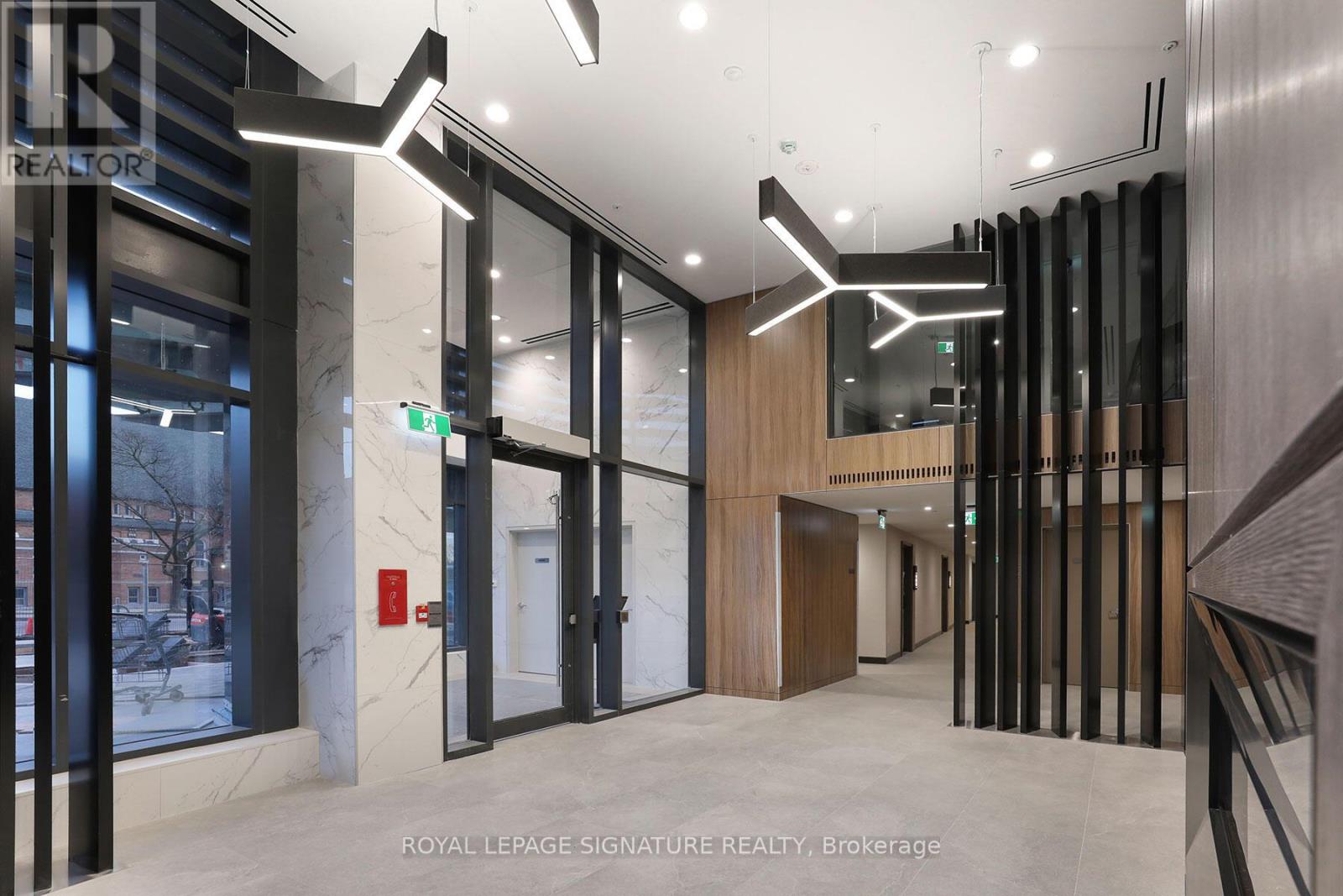 A hallway with a glass wall and a white door.