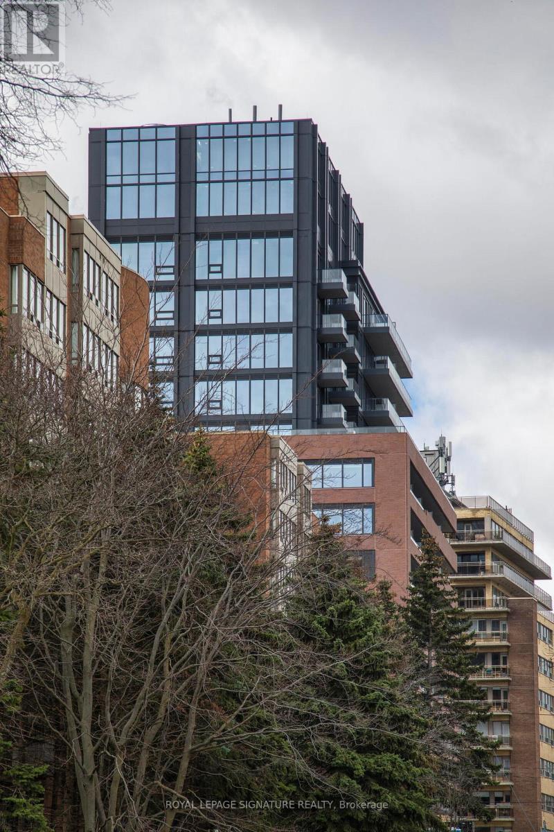 A tall building with many windows stands next to a shorter building with fewer windows.
