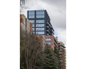 A tall building with many windows stands next to a shorter building with fewer windows.