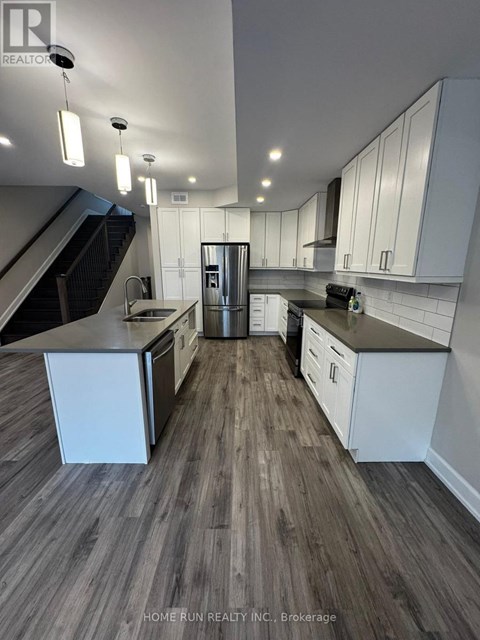 A modern kitchen with white cabinets and a stainless steel refrigerator.