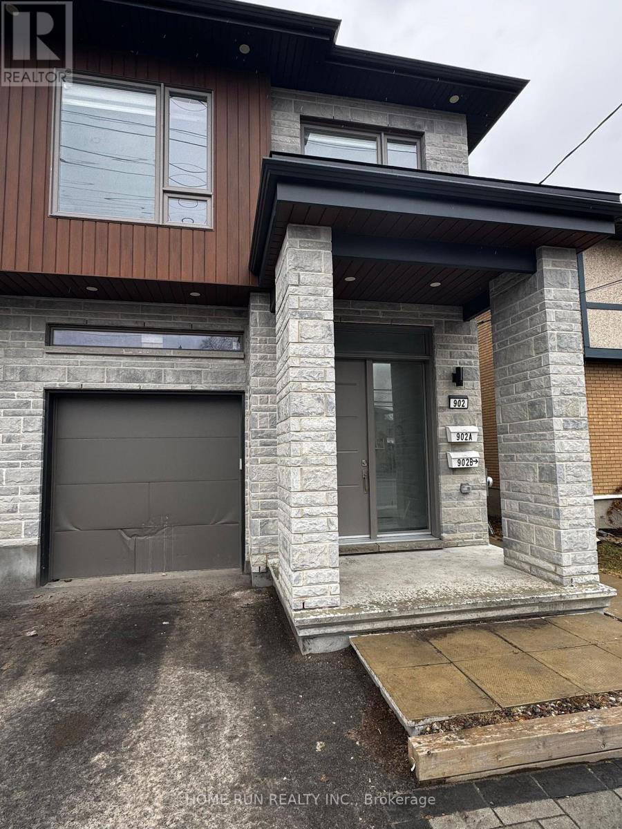 A modern house with a stone pillar entrance and a garage door.