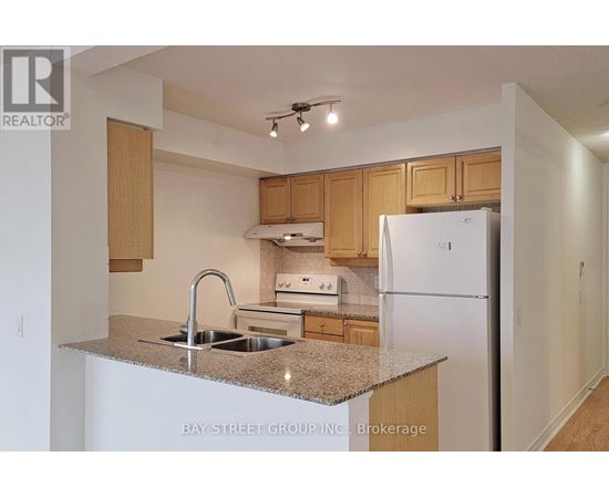 A kitchen with a sink, stove and refrigerator.