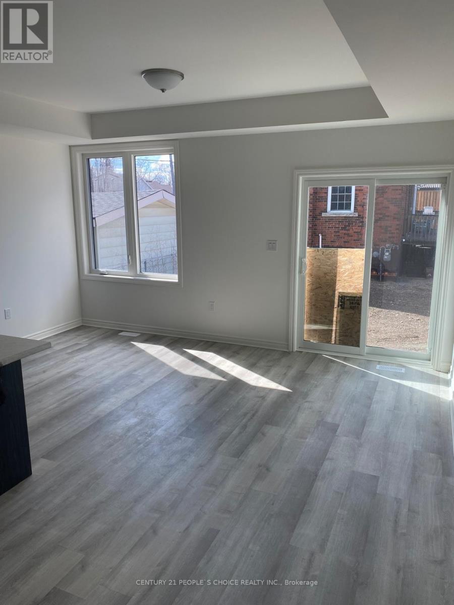 A room with a grey floor and a window showing a view of a building outside.