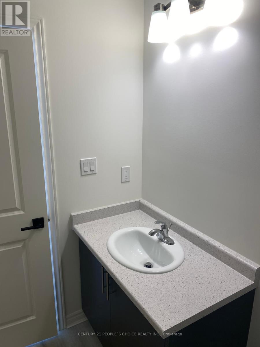 A white sink in a bathroom with a light on.