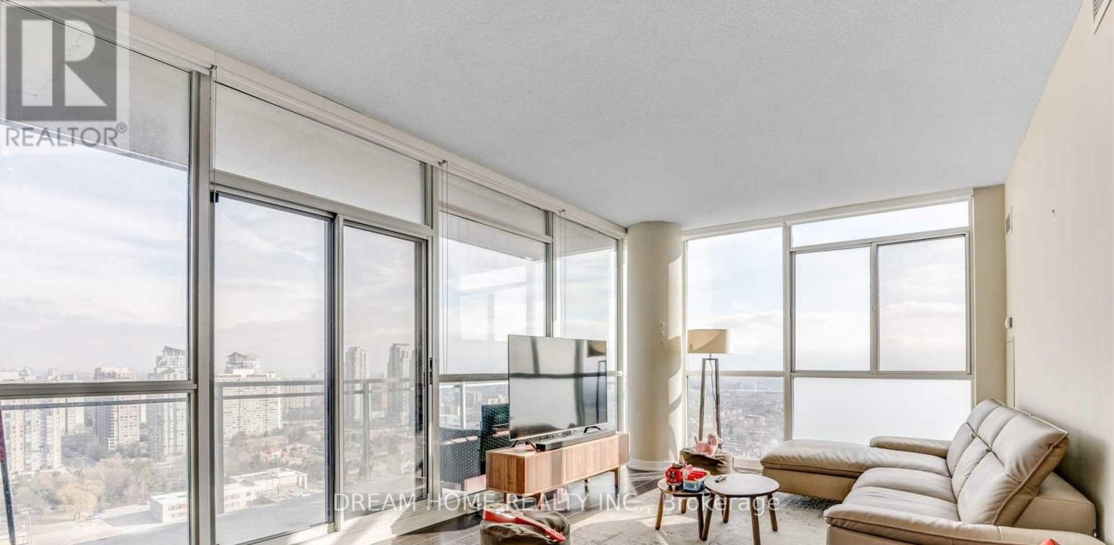 A living room with a large window overlooking a cityscape.
