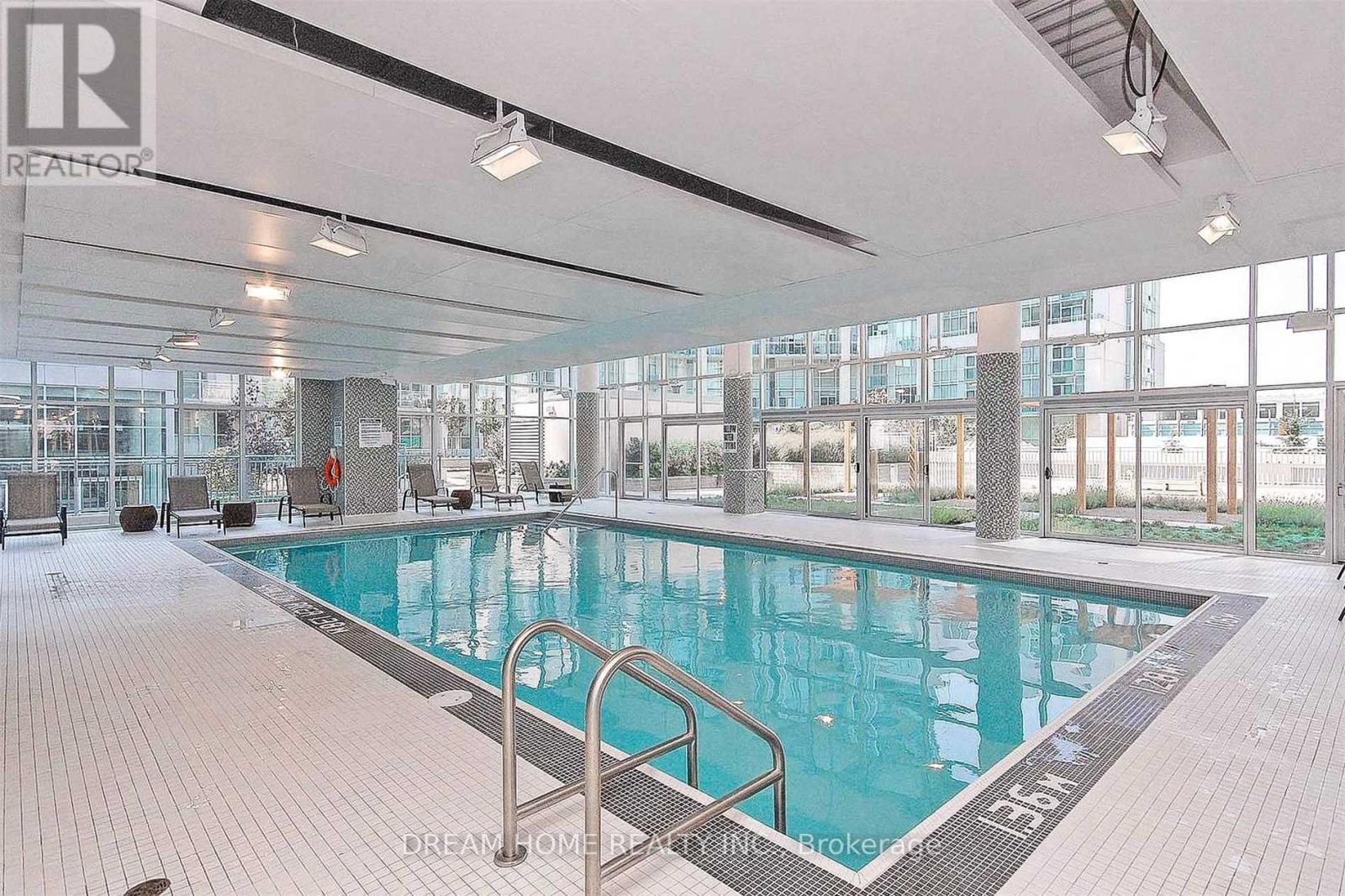 A large indoor swimming pool with a glass wall on one side.