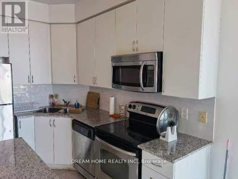 A kitchen with white cabinets and a granite countertop.