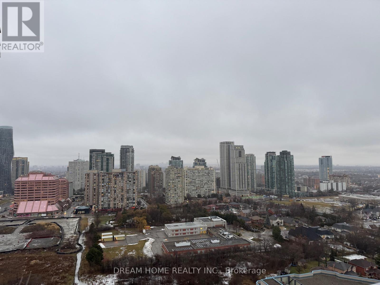 A cityscape with a mix of residential and commercial buildings under a cloudy sky.