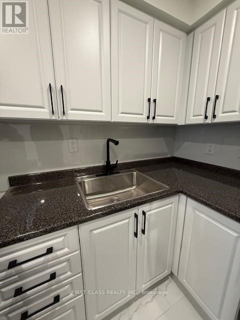 A kitchen with white cabinets and a granite countertop.