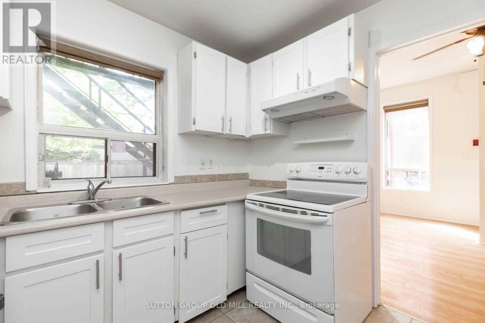 A kitchen with white cabinets and appliances.