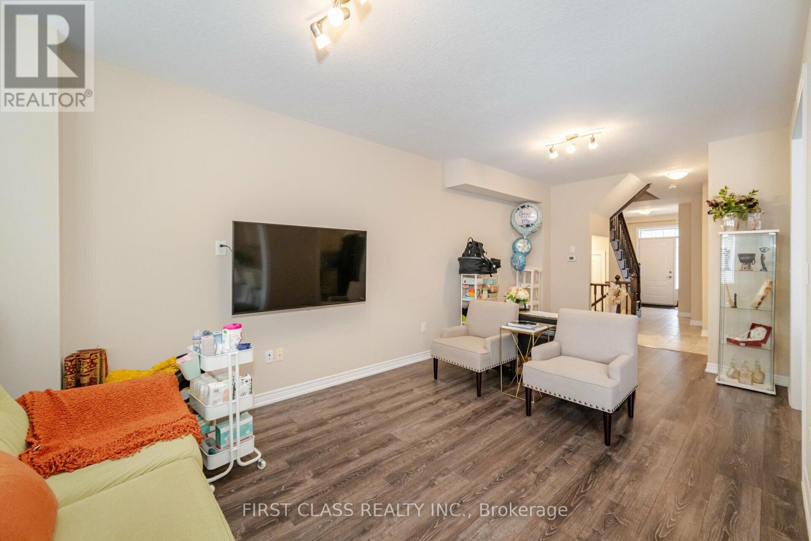 A living room with a flat screen TV mounted on the wall.
