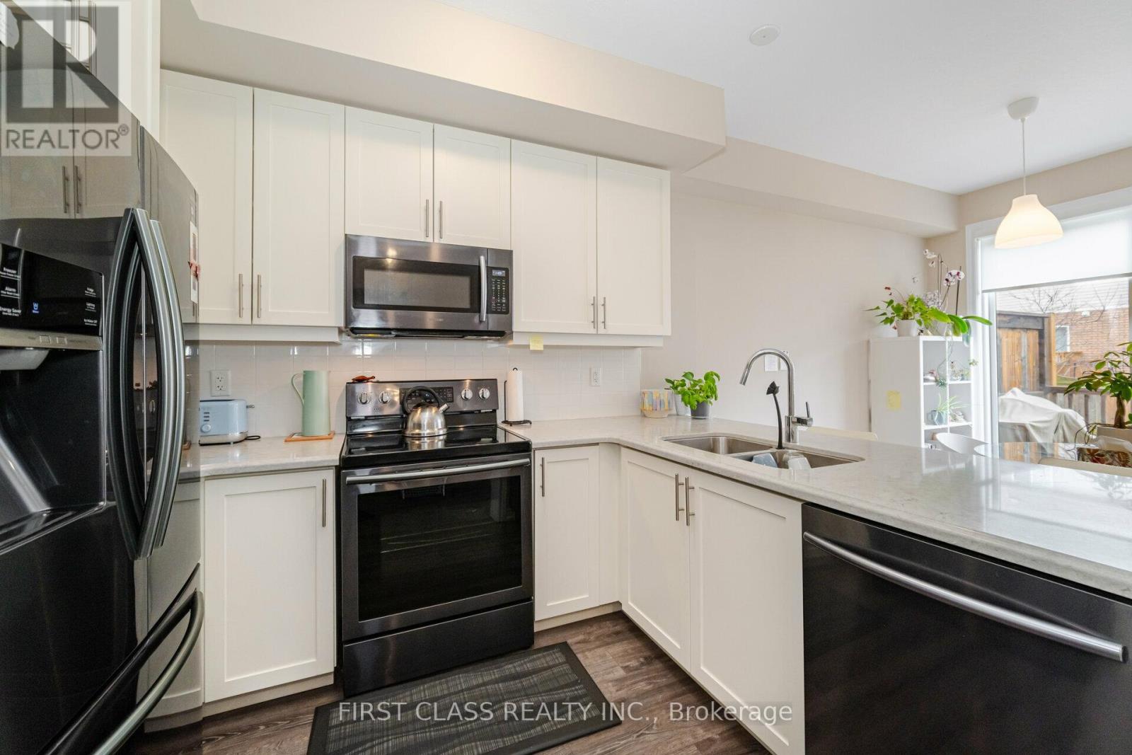 A kitchen with white cabinets and black appliances.