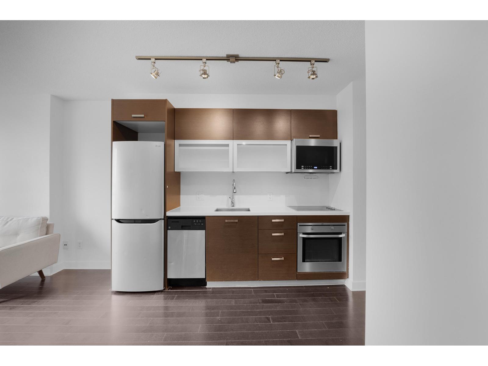 A modern kitchen with brown cabinets and white appliances.