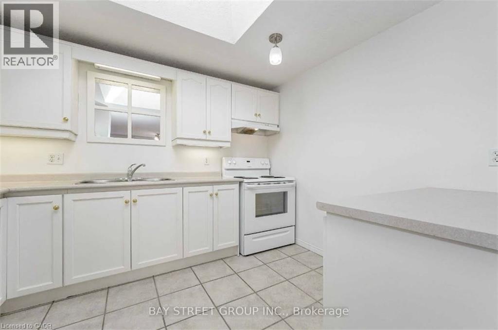 A kitchen with white cabinets and a window.