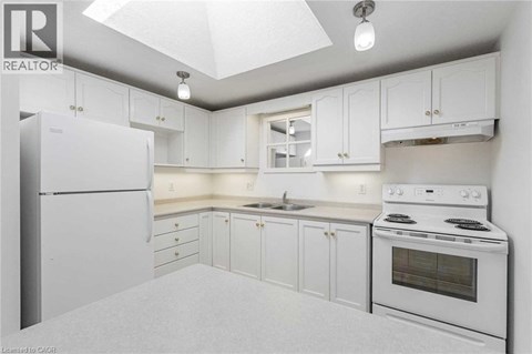 A kitchen with white cabinets and a window.