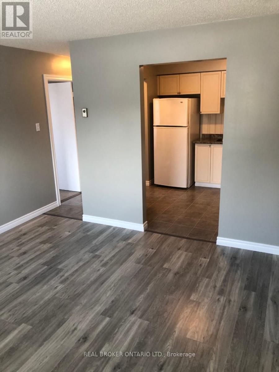 A kitchen area with a refrigerator and cabinets.