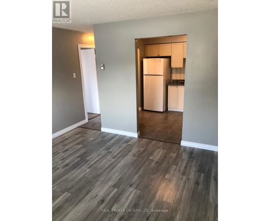 A kitchen area with a refrigerator and cabinets.