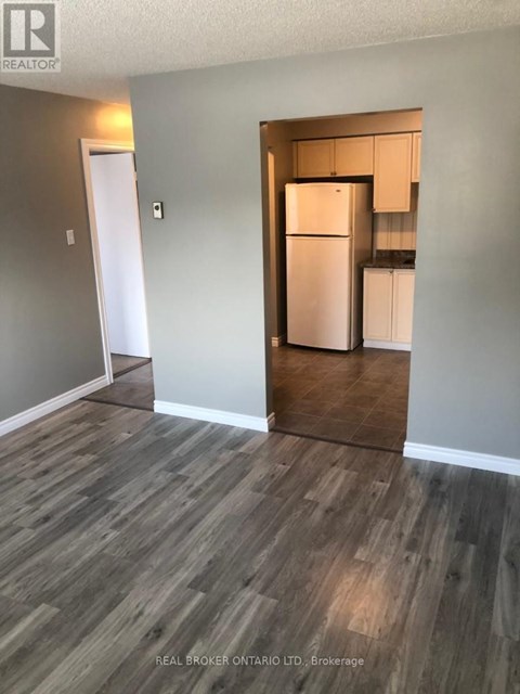 A kitchen area with a refrigerator and cabinets.