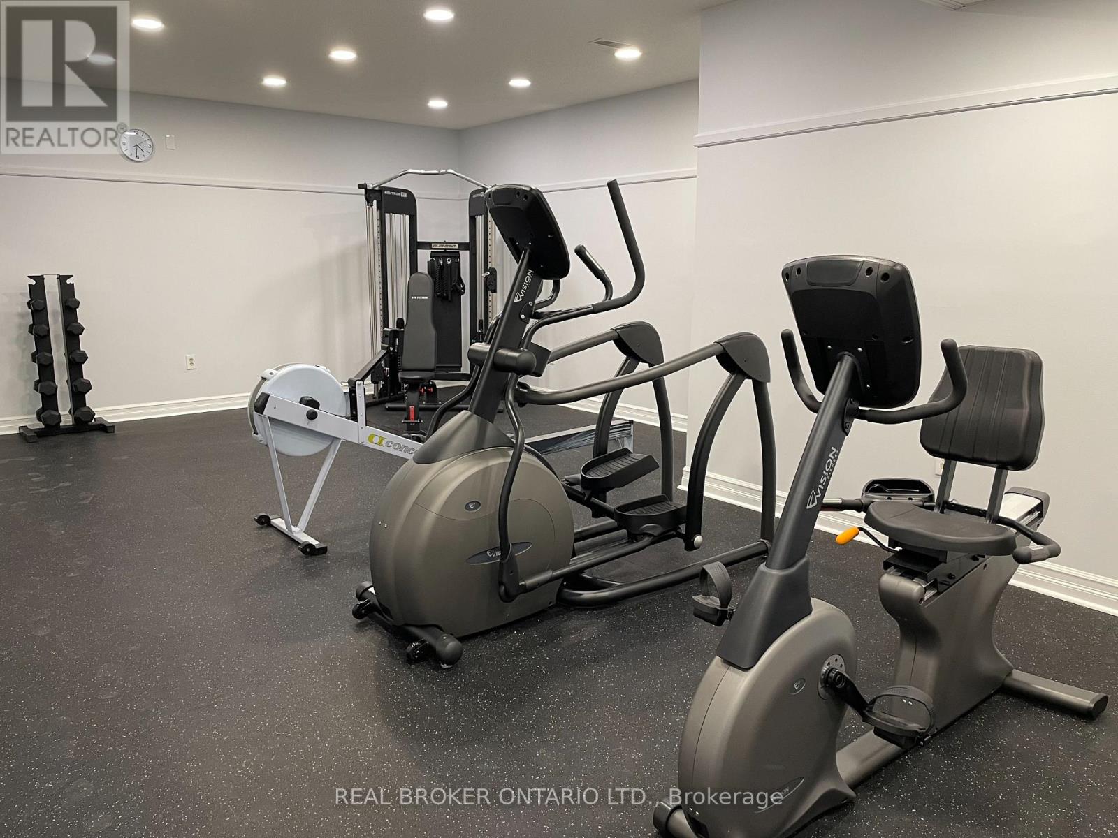 A gym with a variety of equipment including a rowing machine, a leg press machine, and a stationary bike.