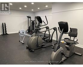 A gym with a variety of equipment including a rowing machine, a leg press machine, and a stationary bike.