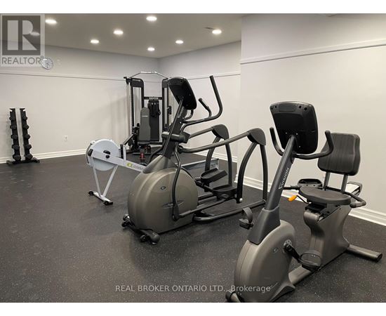 A gym with a variety of equipment including a rowing machine, a leg press machine, and a stationary bike.