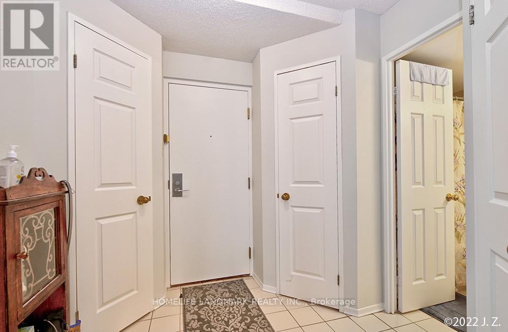 A hallway with three doors and a wooden cabinet on the left.