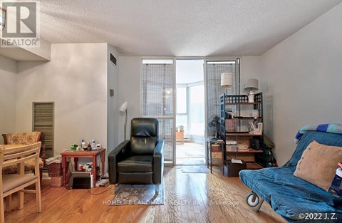 A living room with a black leather chair and a blue sofa.