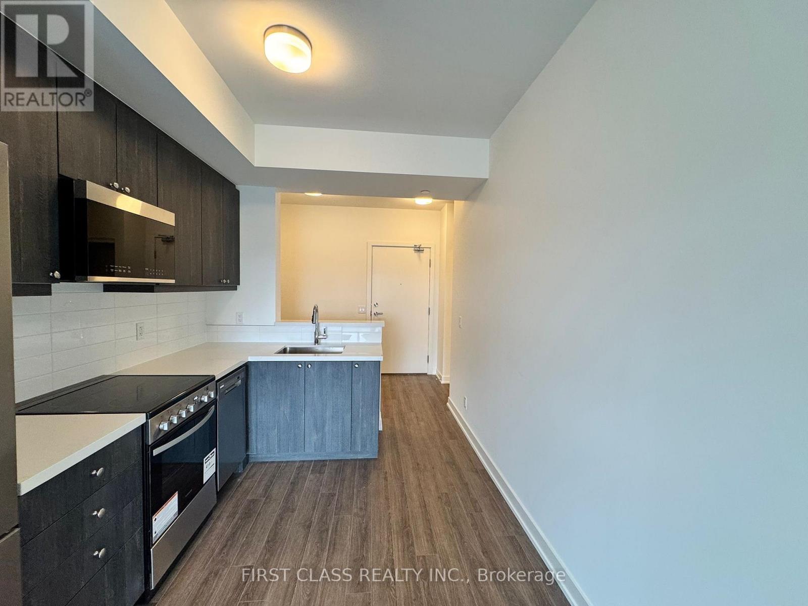A kitchen with dark wood cabinets and a white countertop.