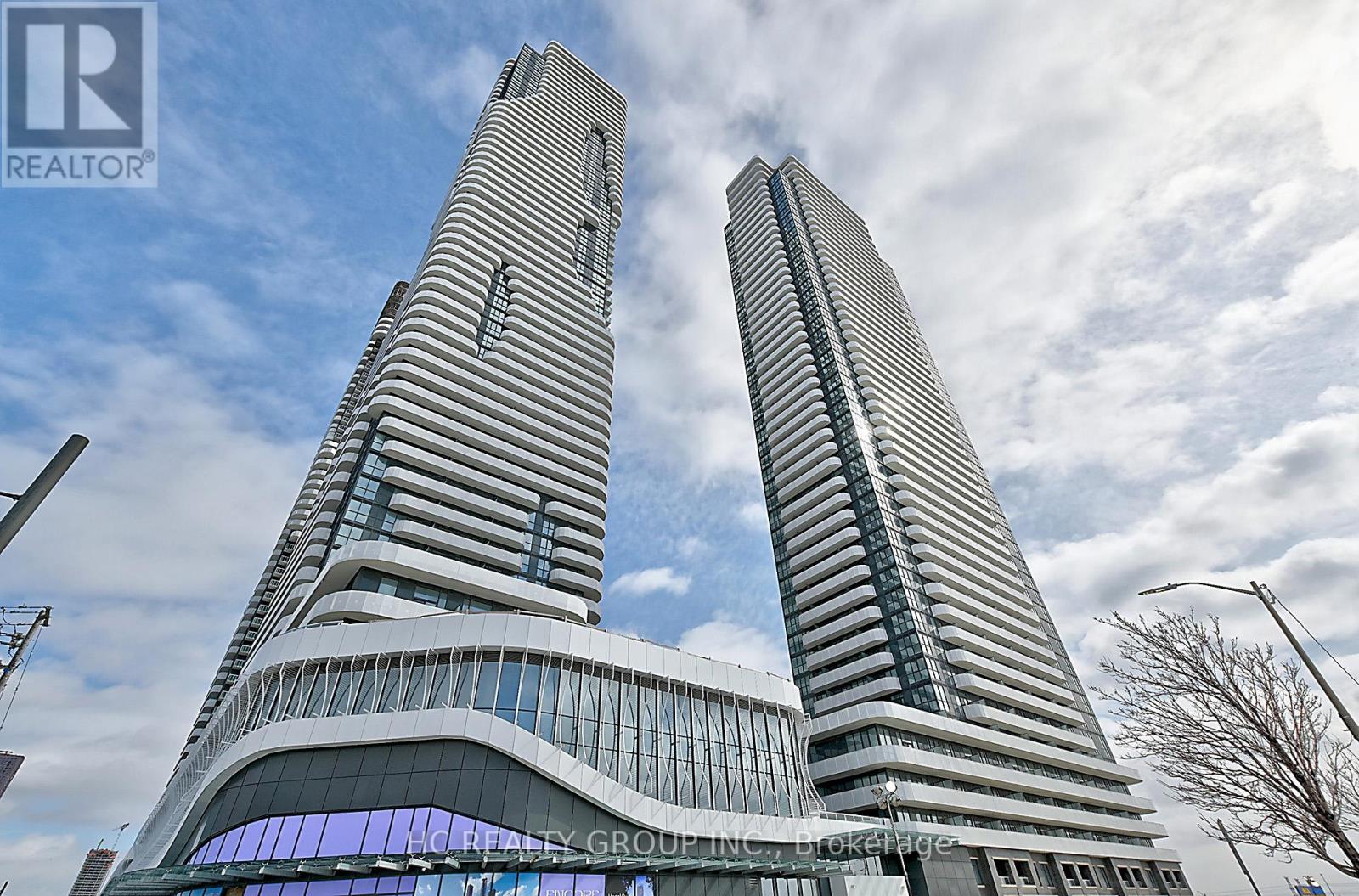 Two tall buildings with glass windows and a blue sky in the background.