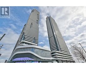 Two tall buildings with glass windows and a blue sky in the background.