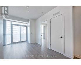 A spacious room with a sliding glass door and a white door.